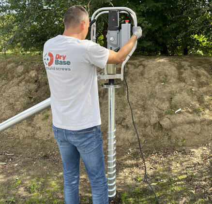 Drybase technieker plaatst grondschroef voor fundering